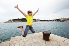 Young Cheerful Woman Jumping On The Pier Stock Image