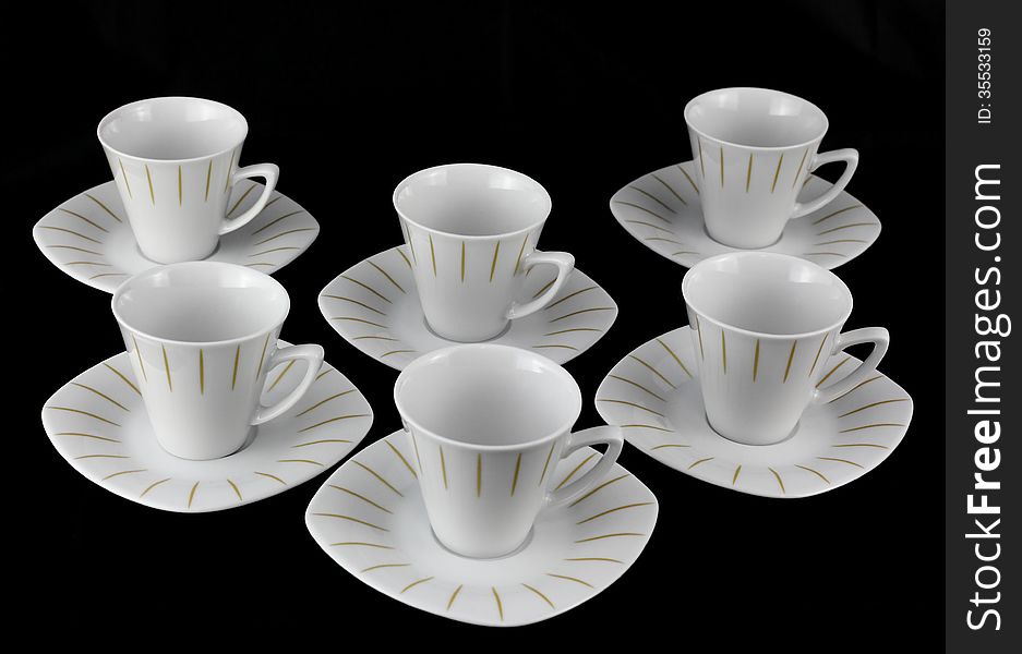 White porcelain tea set on a black background. White porcelain tea set on a black background.