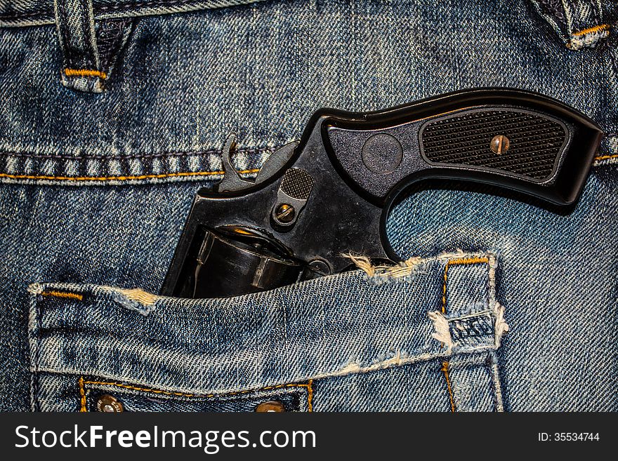 Background, texture, jeans and a revolver in his pocket
