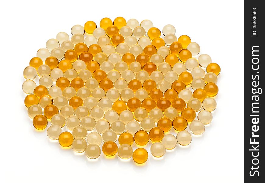 Many transparent, yellow pills with cod-liver oil on a black background