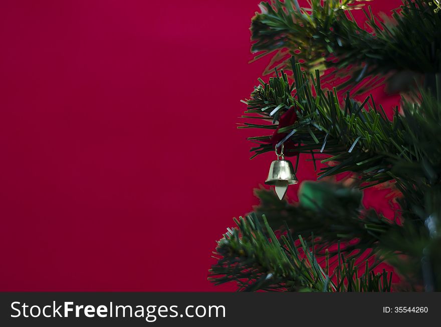 Small Bell On Christmas Tree On Red Background