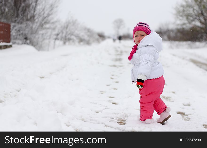 Little girl walking on the road with snow. Little girl walking on the road with snow