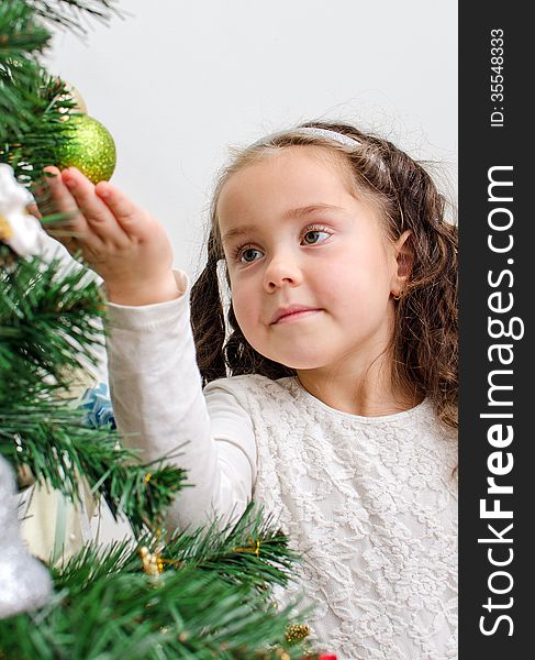 Little girl decorates the Christmas tree. Little girl decorates the Christmas tree