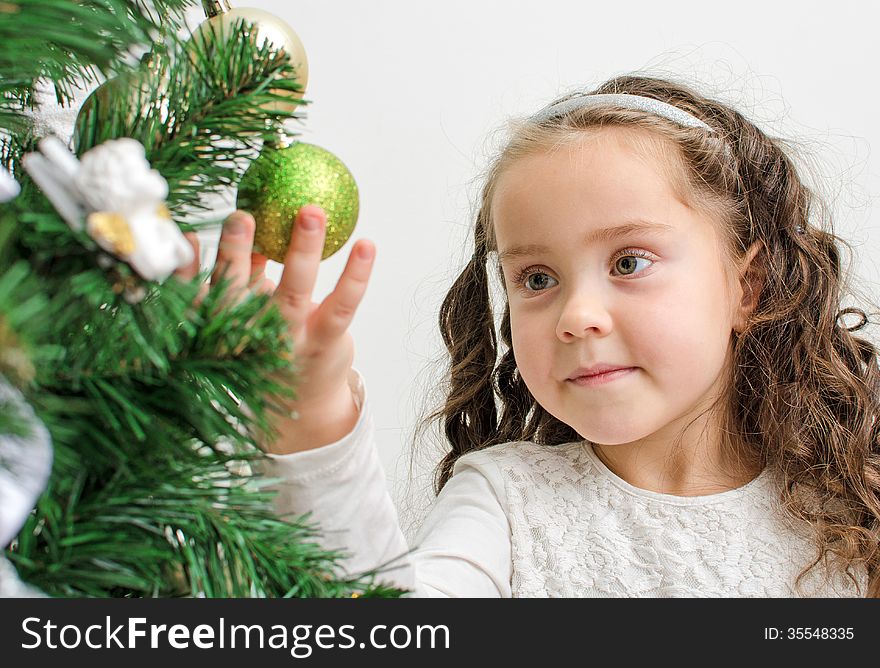 Little girl decorates the Christmas tree. Little girl decorates the Christmas tree