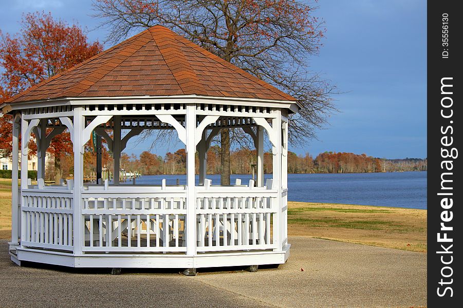 Photo of a white wooden gazebo on the banks of a river