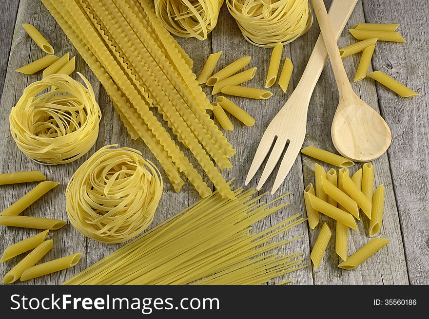 Vintage macaroni background on wood with spoon and fork