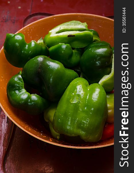 Cleaned and washed bell-peppers in a plastic bowl. Cleaned and washed bell-peppers in a plastic bowl