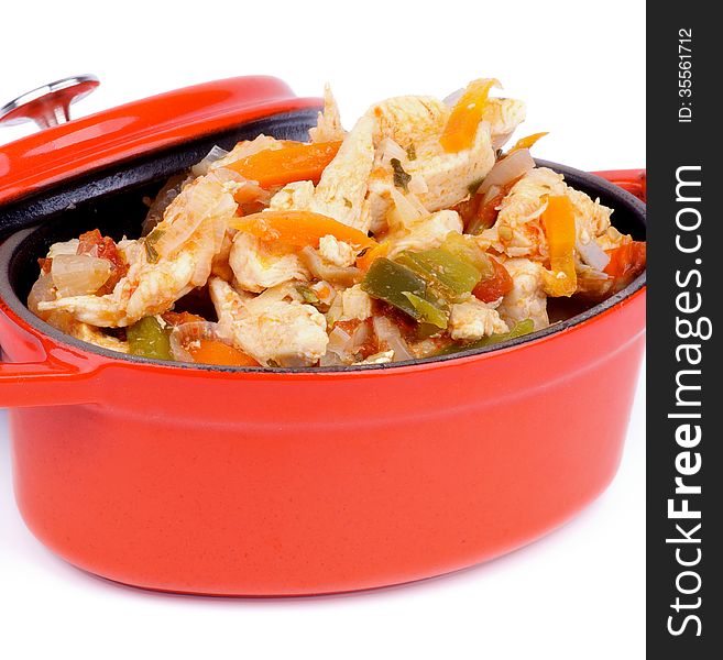 Homemade Chicken Breast Stew with Carrot, Leek and Bell Pepper in Orange Pot closeup on white background. Homemade Chicken Breast Stew with Carrot, Leek and Bell Pepper in Orange Pot closeup on white background