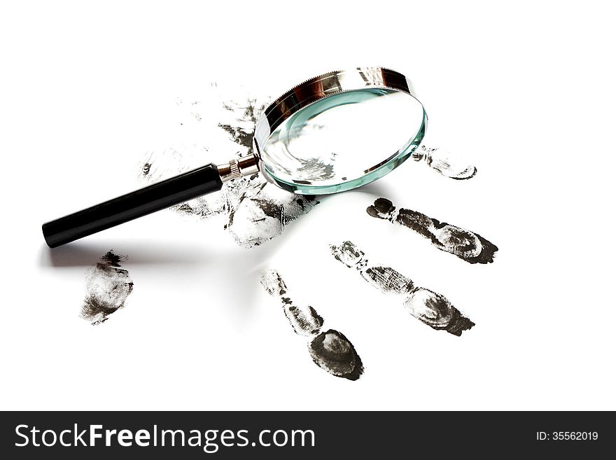 Crime concept. Black fingerprints and magnifying glass on white background