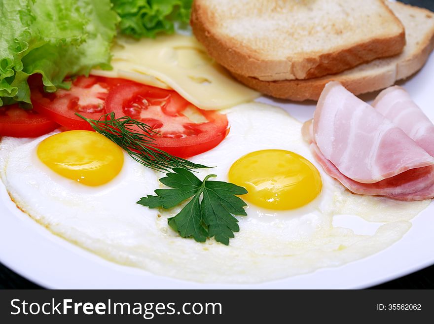 Closeup of plate with fried eggs, toasts and cheese