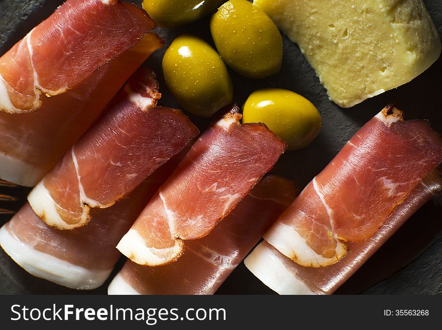 Prosciutto with olives and cheese overhead shoot