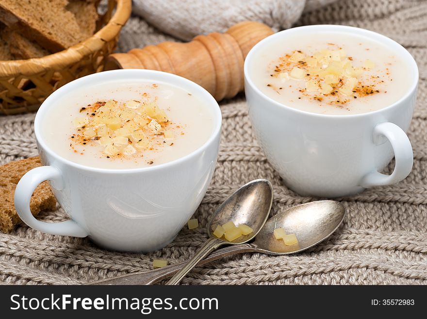 Cream soup of cauliflower with cheese and pepper in a cups, close-up