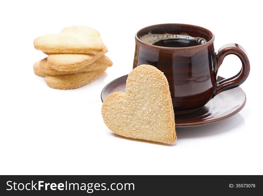 Cup of black coffee and cookies in the shape of heart, isolated on white