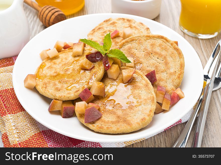 Homemade pancakes with peaches and honey, top view