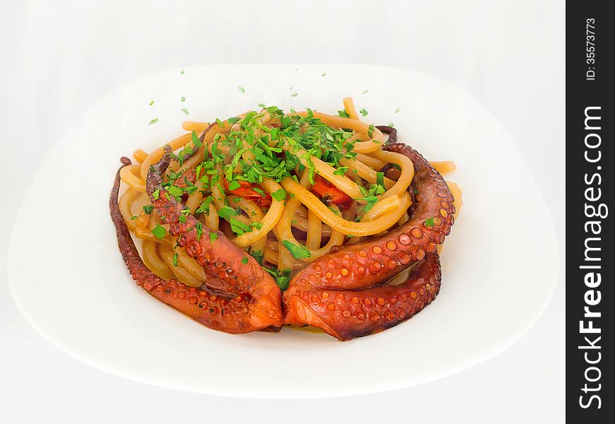 Typical dish of Italian and mediterranean cuisine, made from fresh pasta, cherry tomatoes, octopus, olive oil and parsley. Typical dish of Italian and mediterranean cuisine, made from fresh pasta, cherry tomatoes, octopus, olive oil and parsley.