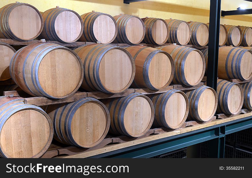 Casks in wine cellar and bottle at the winery