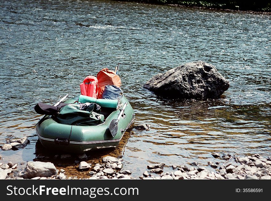 The rubber boat on water near a big stone, summer sunny day. The rubber boat on water near a big stone, summer sunny day