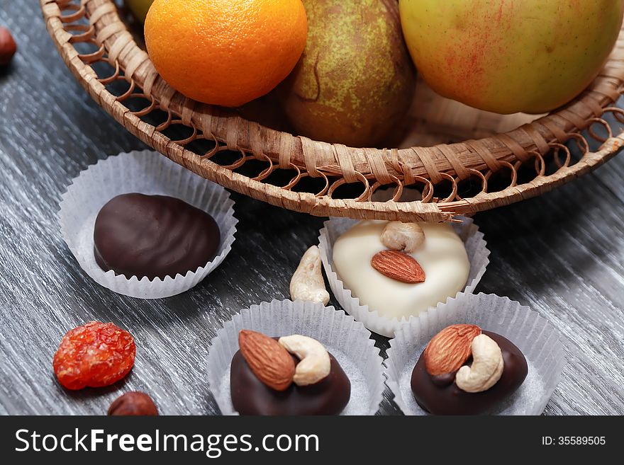 Few chocolate candies and nuts on wooden table. Few chocolate candies and nuts on wooden table