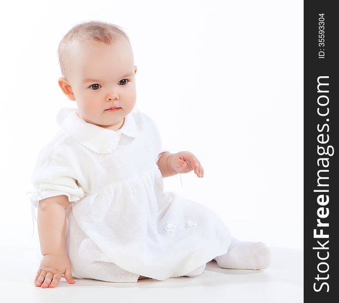 Little baby girl sitting on the floor, isolated on white