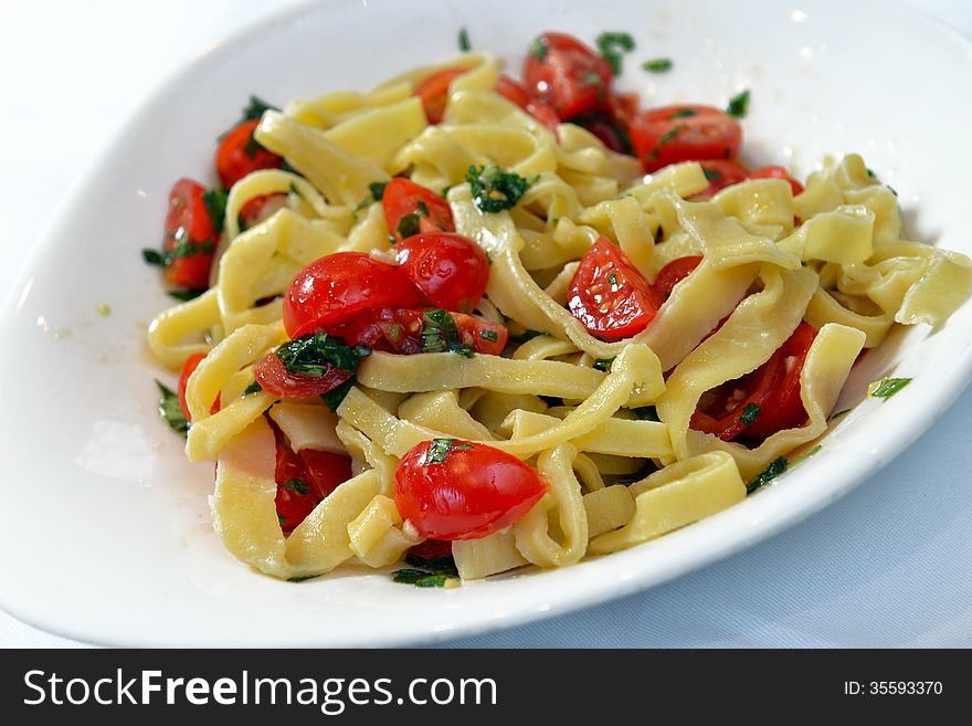 Pasta with cherry tomatoes and basil in a bowl