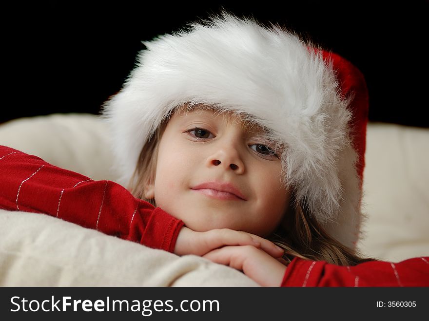 A beautiful young girl wearing a santa hat. A beautiful young girl wearing a santa hat