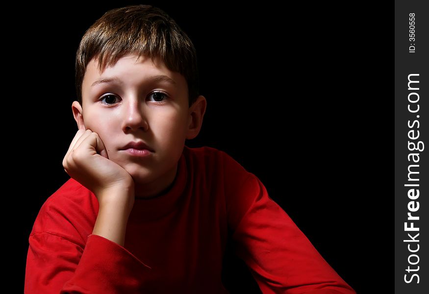 The thoughtful boy in a dark room