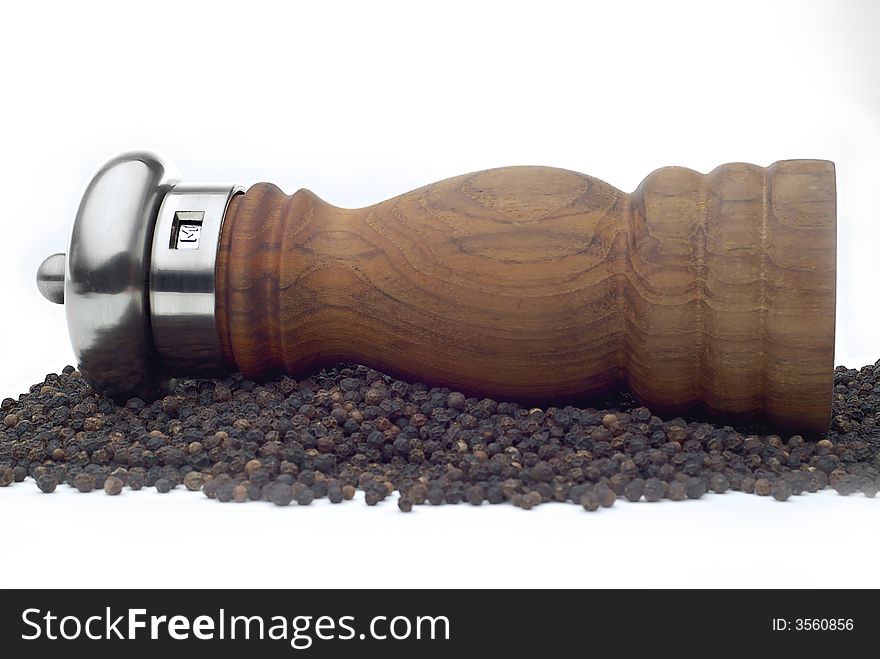 Pepper mill laying on pepper on white background. Pepper mill laying on pepper on white background