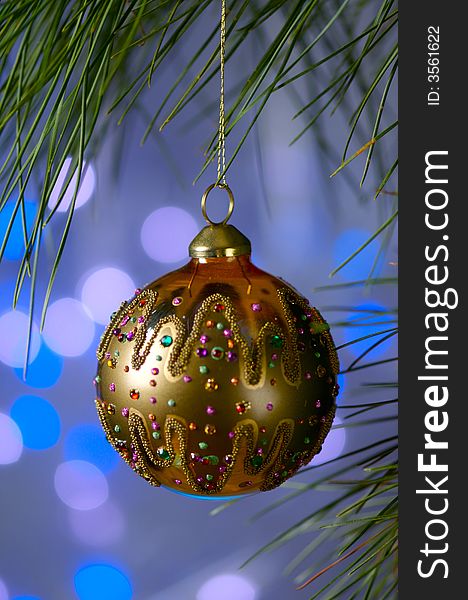 An image of a gold Christmas ornament on a blue background