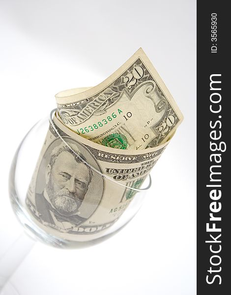 Dollar bills in the glass for wine isolated on light gray. Dollar bills in the glass for wine isolated on light gray