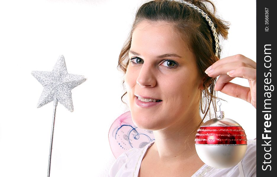 A young beautiful cute and happy Christmas fairy with wings and a magic wand getting ready for Christmas! Isolated over white!. A young beautiful cute and happy Christmas fairy with wings and a magic wand getting ready for Christmas! Isolated over white!