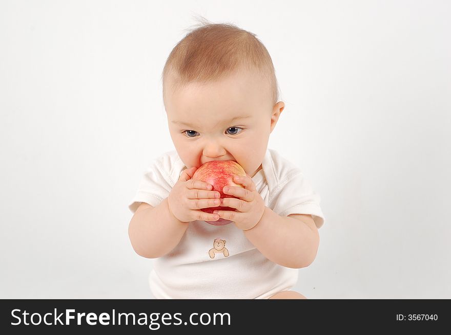 Sweet baby eating apple on white background. Sweet baby eating apple on white background