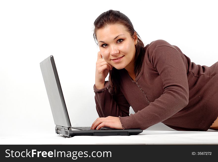 Attractive brunette woman lying with laptop on white background. Attractive brunette woman lying with laptop on white background