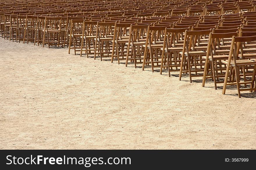 Rows of wooden chairs on sand. Rows of wooden chairs on sand