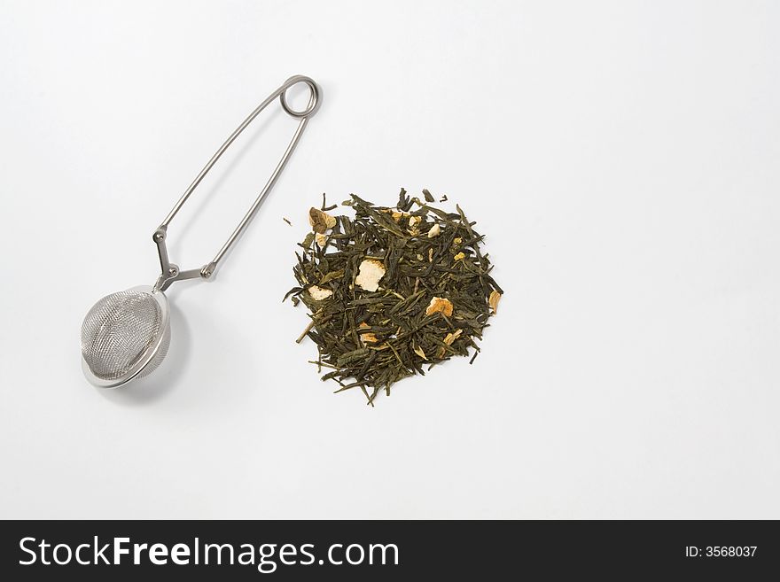 Tea skimmer with dried green tea leaves and orange husk