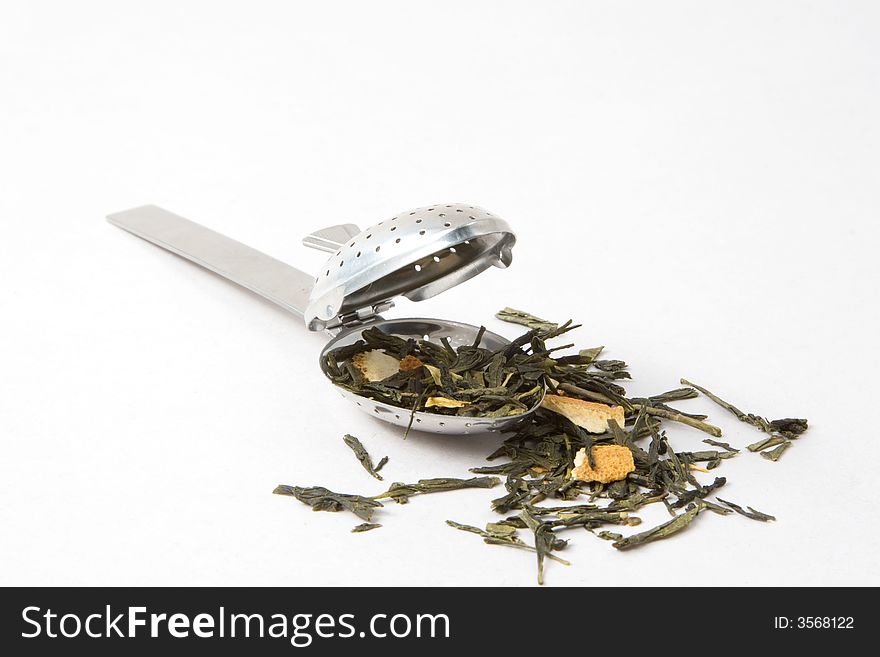 Tea skimmer with dried green tea leaves and orange husk