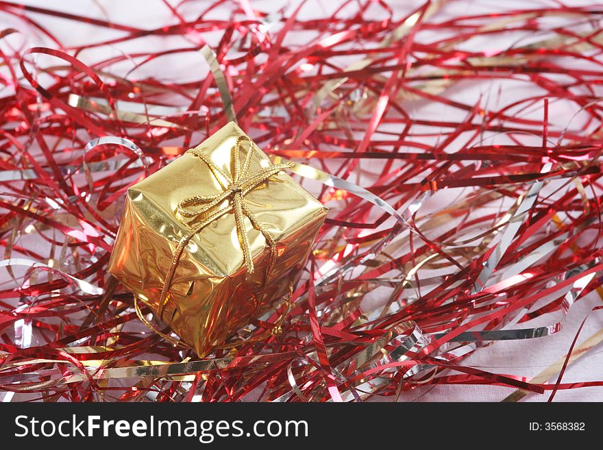 Gold gift box in red tinsel.