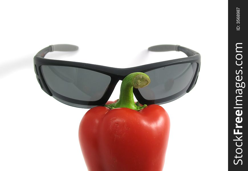 The creative image the image of pepper in glasses isolated on white. The creative image the image of pepper in glasses isolated on white