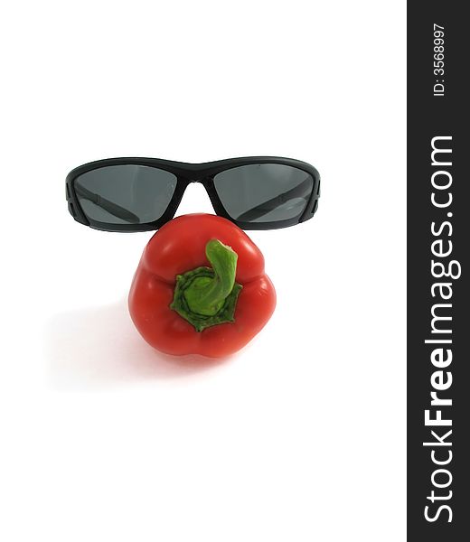 The creative image the image of pepper in glasses isolated on white. The creative image the image of pepper in glasses isolated on white