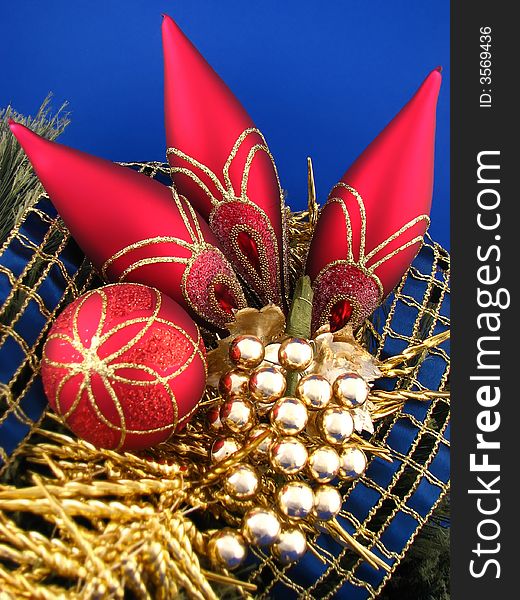 Four red Christmas bulbs on blue background