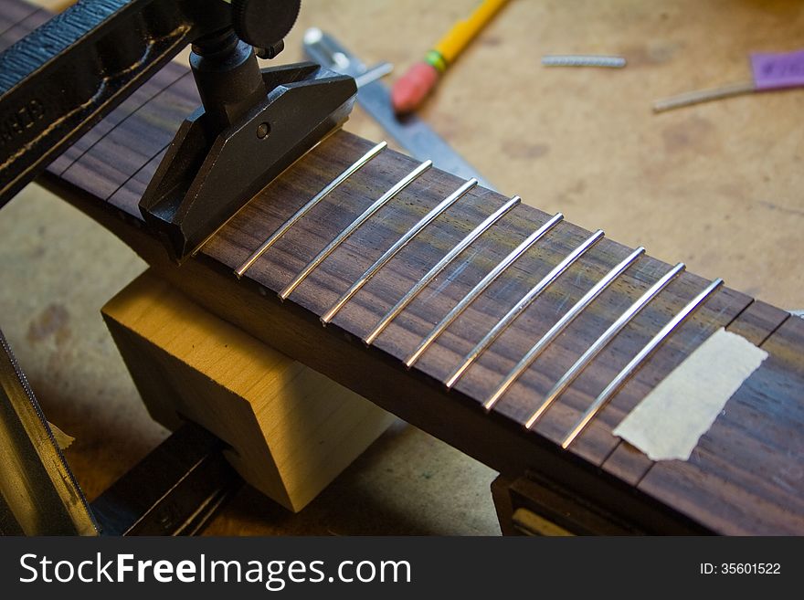 Installing frets in a guitar neck. Installing frets in a guitar neck