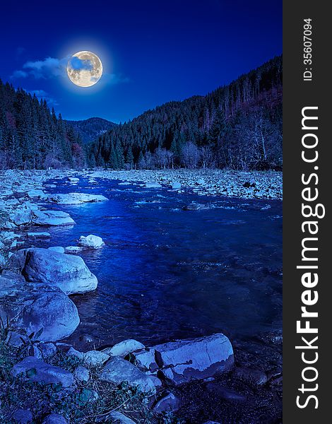 River flows by rocky shore near the autumn mountain forest at night. River flows by rocky shore near the autumn mountain forest at night