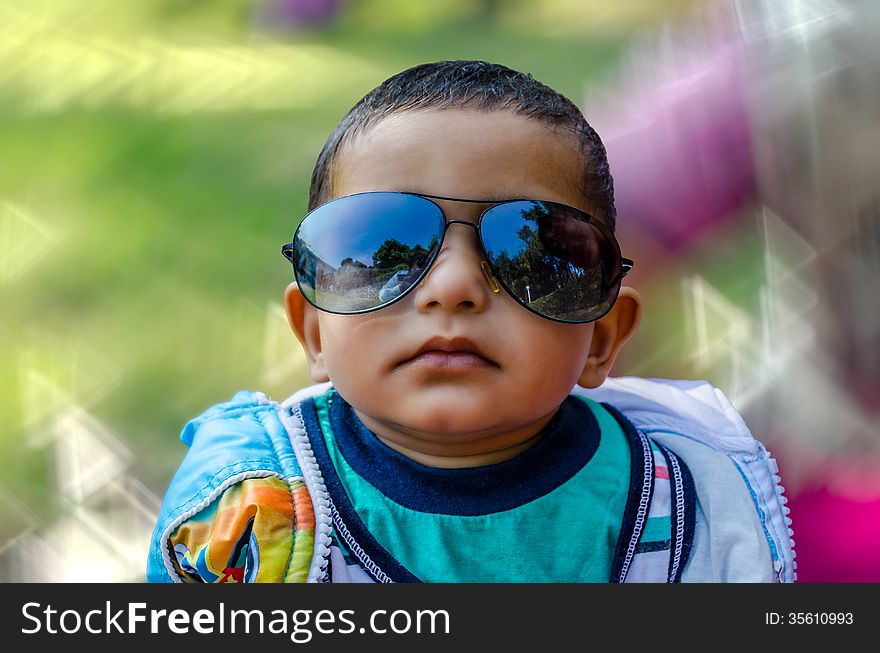 Portrait of cute funny baby boy looking at camera with sun glasses on his face. Portrait of cute funny baby boy looking at camera with sun glasses on his face