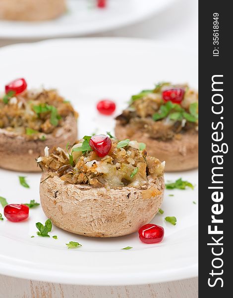 Appetizer - stuffed mushrooms with herbs and pomegranate seeds, close-up, vertical