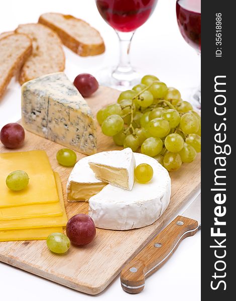 Cheese platter, grapes, ciabatta and two glass of red wine, close-up, vertical. Cheese platter, grapes, ciabatta and two glass of red wine, close-up, vertical