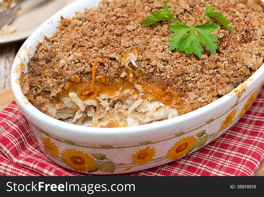 Gratin with fish and pumpkin in a ceramic form, close-up