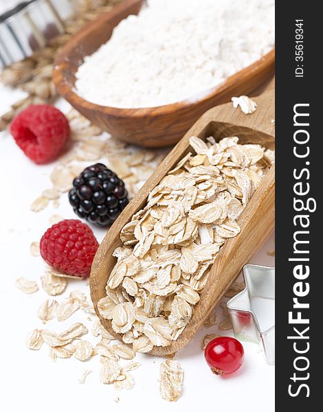 Oatmeal, flour, eggs and berries - the ingredients for baking cookies, close-up, vertical. Oatmeal, flour, eggs and berries - the ingredients for baking cookies, close-up, vertical