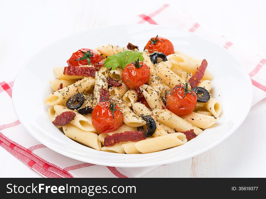 Pasta with sausage, tomatoes and olives, close-up