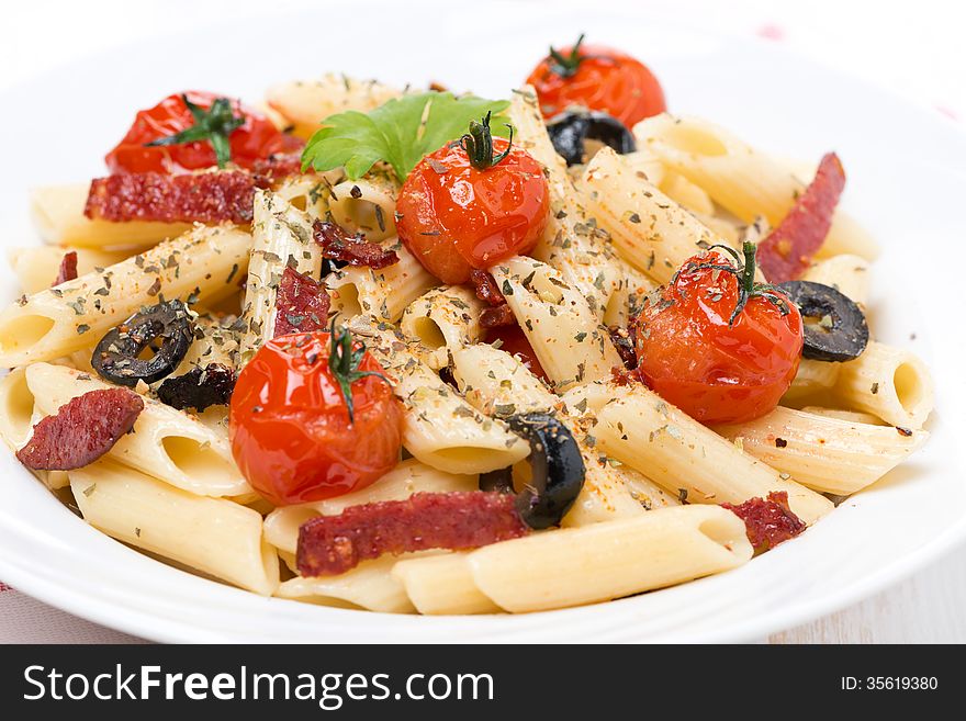 Pasta with sausage, tomatoes and olives, close-up