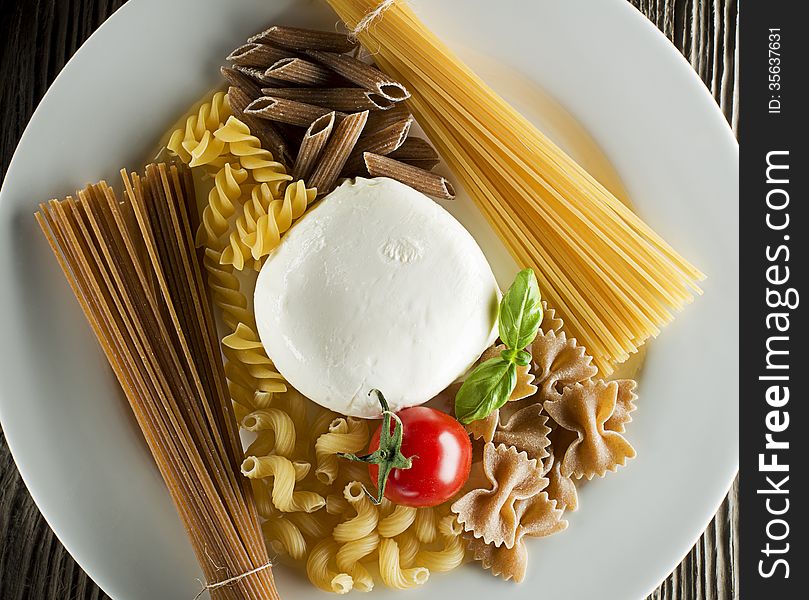 Raw pasta with basil, mozzarellal and tomato overhead shoot
