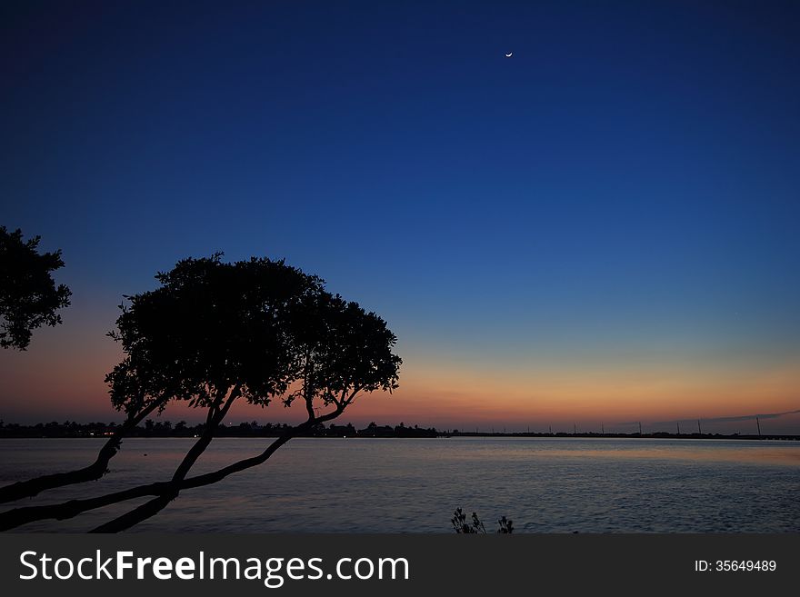 Looking out across the Keys in Florida just after sunset. The sky created brilliant colors grading from deep blue through to pink and a crescent moon also made an appearance. Looking out across the Keys in Florida just after sunset. The sky created brilliant colors grading from deep blue through to pink and a crescent moon also made an appearance.